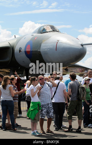 I visitatori al salone di Farnborough in piedi al di sotto di una storica bombardiere Vulcan aerei per guardare il display di volo Foto Stock