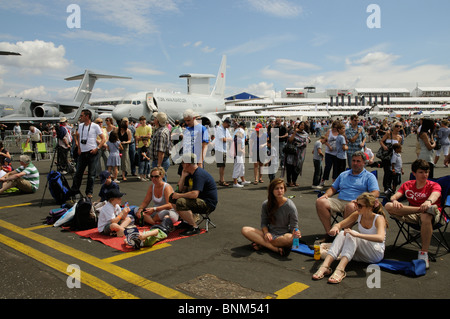 La folla a Farnborough Air Show in piedi e seduto in aereo statico area di visualizzazione del luglio 2010 Foto Stock