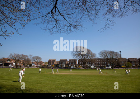 Inghilterra, West Sussex, Southwick, locale squadra di cricket giocando sul verde del villaggio. Foto Stock