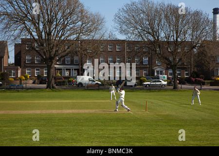 Inghilterra, West Sussex, Southwick, locale squadra di cricket giocando sul verde del villaggio. Foto Stock