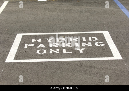 "Ibrido parcheggio solo segno è dipinta in un parcheggio che designa il parcheggio che è riservato per i veicoli ibridi. Foto Stock