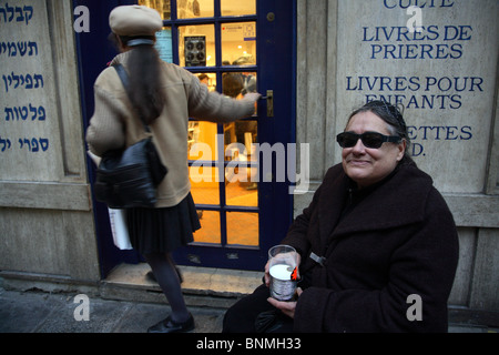 Donna raccogliendo denaro per Hanukkah davanti a una libreria Ebraica, Parigi, Francia Foto Stock