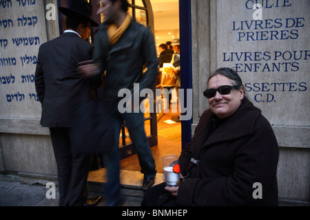 Donna raccogliendo denaro per Hanukkah davanti a una libreria Ebraica, Parigi, Francia Foto Stock