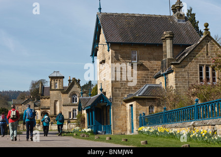 Escursionisti a piedi attraverso il villaggio di Edensor sul Chatsworth Estate, il Parco Nazionale di Peak District, Derbyshire. Foto Stock