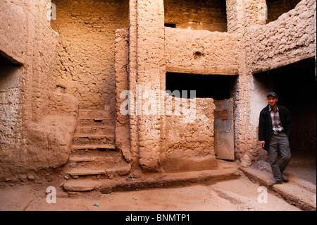 Lavoratore marocchino in un patio, fango tradizionale edificio di mattoni, Figuig, provincia di Figuig, della Regione Orientale, Marocco. Foto Stock