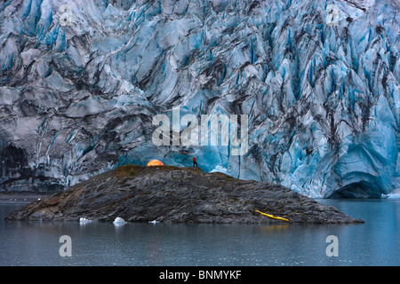 Kayaker e barca tirata su un isola di fronte del ghiacciaio Shoup, Shoup stato Bay Marine Park, Prince William Sound, Alaska Foto Stock