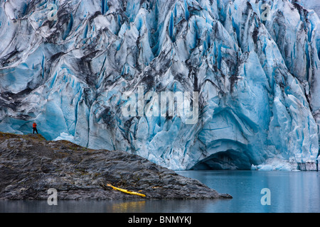 Kayaker e barca tirata su un isola di fronte del ghiacciaio Shoup, Shoup stato Bay Marine Park, Prince William Sound, Alaska Foto Stock