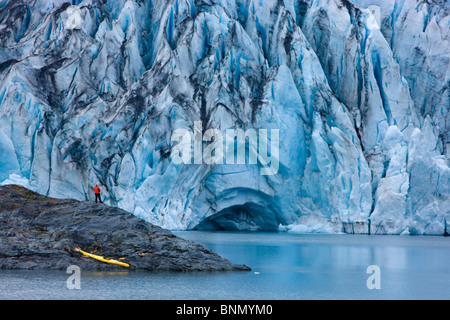 Kayaker e barca tirata su un isola di fronte del ghiacciaio Shoup, Shoup stato Bay Marine Park, Prince William Sound, Alaska Foto Stock