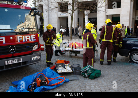 Salvataggio simulato di car crash vittima dai vigili del fuoco e paramedici per te esercizio Foto Stock