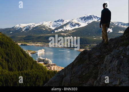 Un escursionista prende in vista del canale Gastineau, Mt. Jumbo, e il centro cittadino di Juneau dal lato di Mt. Roberts in Alaska, estate Foto Stock