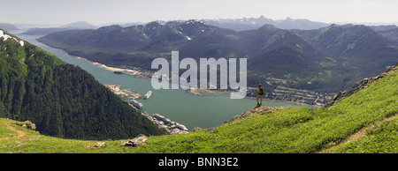 Un escursionista prende in vista del canale Gastineau, Isola di Douglas e il centro cittadino di Juneau dalla sommità del Mt. Juneau in Alaska Foto Stock