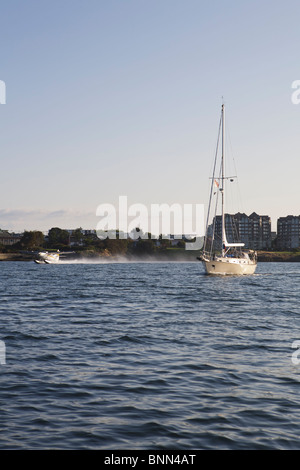 Una barca a vela ed un mare piano partono da Victoria BC, Canada Foto Stock