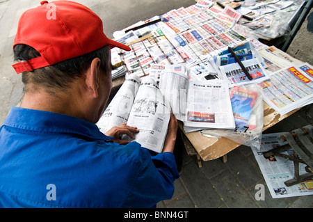 Lettura dei giornali presso un chiosco di Pechino. Foto Stock