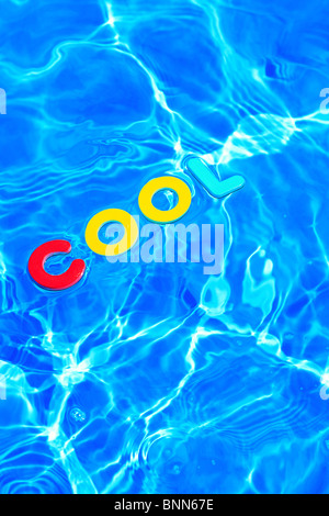 La parola COOL di schiuma lettere galleggianti sulla superficie dell'acqua di piscina Foto Stock