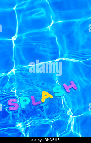La parola splash di schiuma lettere galleggianti sulla superficie dell'acqua di piscina Foto Stock