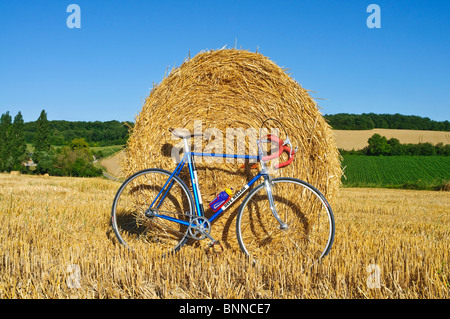 Ruota fissa bicicletta nella parte anteriore del round di balle di paglia - Indre-et-Loire, Francia. Foto Stock