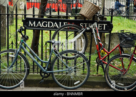 Biciclette rinchiuse su ringhiere a Magdalen Street, Oxford, Regno Unito Foto Stock