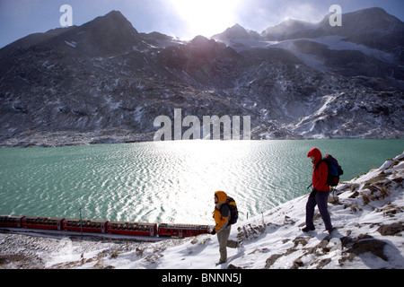 Svizzera Svizzera escursione a piedi del Bernina montagna lago coppia giovane due neve autunno del cantone dei Grigioni Grigioni Bündnerland Foto Stock