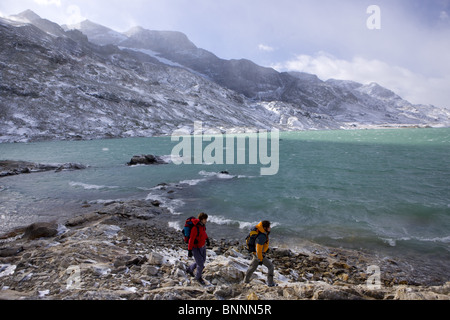 Svizzera Svizzera escursione a piedi del Bernina montagna lago coppia giovane due neve autunno del cantone dei Grigioni Grigioni Bündnerland Foto Stock