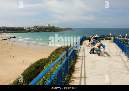 Vacanzieri seduti sulle panchine che si affaccia sulla Spiaggia Great Western in Newquay in Cornovaglia. Foto Stock