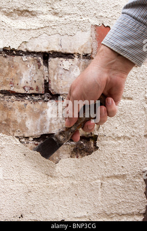 Manutenzione della casa, raschiare la vernice si sfoglia dai mal mantenuta cotto nella necessità di puntare Foto Stock