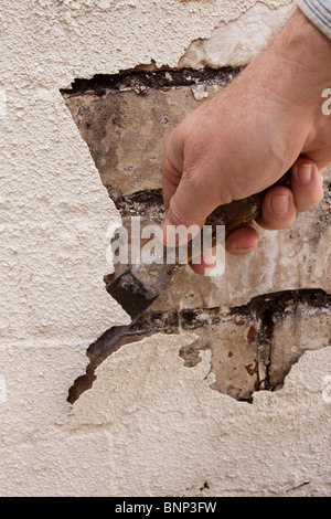 Manutenzione della casa, raschiare la vernice si sfoglia dai mal mantenuta cotto nella necessità di puntare Foto Stock