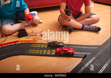 Un modello rilasciato foto di due ragazzi ( 6 & 10 ) suonando con un Hornby Scalextric racing car set game del Regno Unito Foto Stock