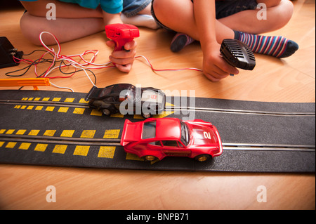 Un modello rilasciato foto di due ragazzi ( 6 & 10 ) suonando con un Hornby Scalextric racing car set game del Regno Unito Foto Stock