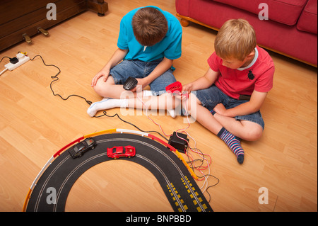 Un modello rilasciato foto di due ragazzi ( 6 & 10 ) suonando con un Hornby Scalextric racing car set game del Regno Unito Foto Stock