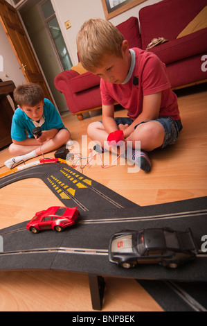 Un modello rilasciato foto di due ragazzi ( 6 & 10 ) suonando con un Hornby Scalextric racing car set game del Regno Unito Foto Stock