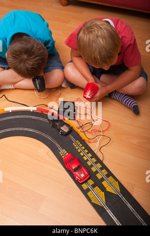 Un modello rilasciato foto di due ragazzi ( 6 & 10 ) suonando con un Hornby Scalextric racing car set game del Regno Unito Foto Stock