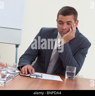 Attraente imprenditore annoiato a una riunione Foto Stock