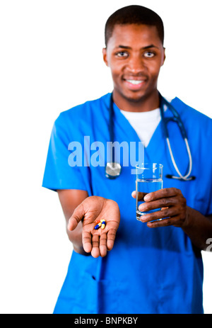 Ritratto di un medico sorridente in frega con le pillole e bicchiere di acqua Foto Stock