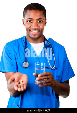 Medico sorridente in frega con le pillole e bicchiere di acqua Foto Stock