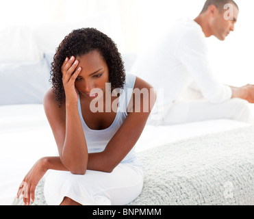 Sconvolto giovane seduto sul letto separatamente Foto Stock