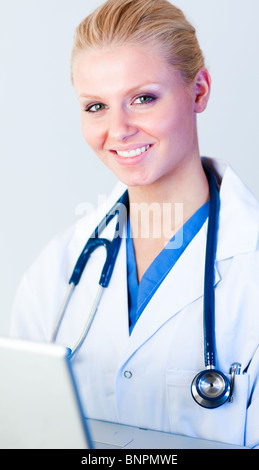 Medico al lavoro su un notebook guardando la fotocamera Foto Stock