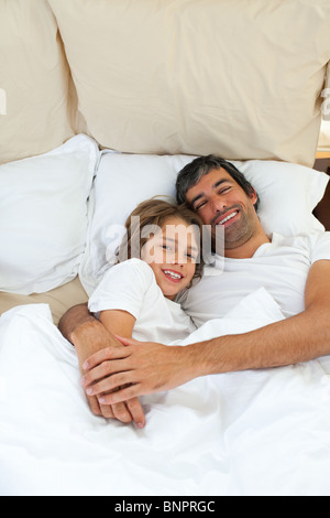 Attraente padre abbraccia il suo figlio Foto Stock