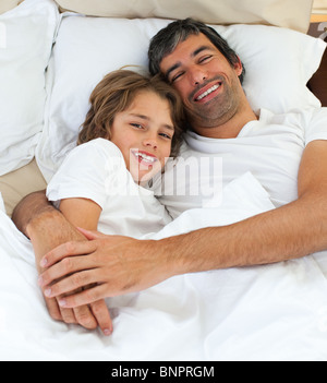 Padre amorevole abbraccia il suo figlio Foto Stock