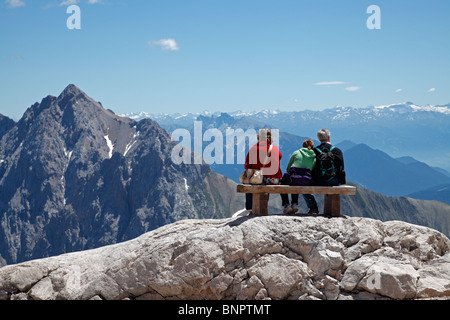 I turisti seduta su una panchina e godendo la vista dal Zugspitze prima gli ultimi metri al vertice su un luminoso giorno di estate Foto Stock