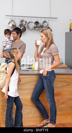 Famiglia di parlare in cucina prima della scuola Foto Stock