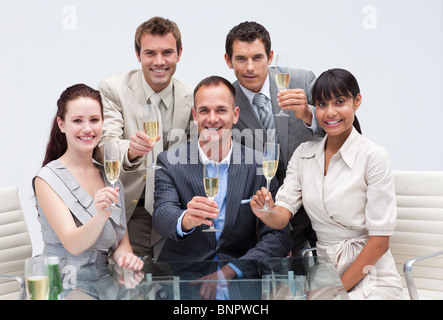 Il team Aziende per celebrare un successo con champagne in ufficio Foto Stock