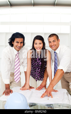 Architetto co-lavoratori rivedendo blueprints Foto Stock