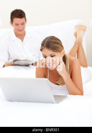 Amare giovane rilassante sul loro letto Foto Stock