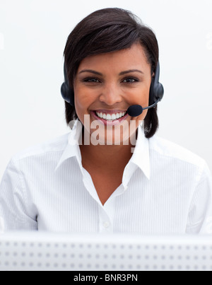 Imprenditrice sorridente con cuffie di un call center Foto Stock