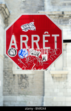 Lingua francese Stop, Arret coperto di graffiti e adesivi Foto Stock