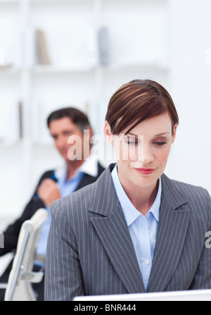 Ritratto di un fiducioso imprenditrice seduto alla scrivania in ufficio Foto Stock