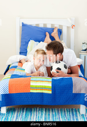 Attraente padre e suo figlio a giocare con un pallone da calcio Foto Stock