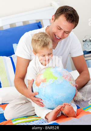 Buon padre e figlio guardando un globo terrestre Foto Stock