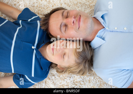 Padre e figlio sdraiato sul pavimento Foto Stock