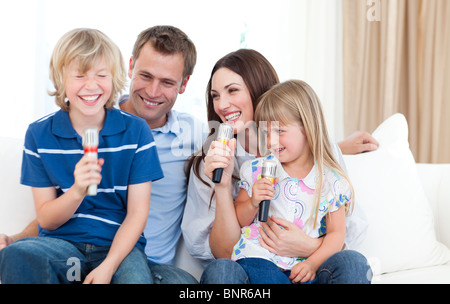Ridendo famiglia cantano insieme Foto Stock